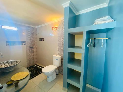 a blue bathroom with a toilet and a sink at Charming room with balcony and ocean view in Essaouira