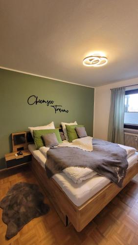 ein Schlafzimmer mit einem großen Bett mit grünen Wänden in der Unterkunft Ferienwohnung Hedy in Prien am Chiemsee