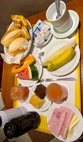 een tafel met borden en een fles wijn bij Hotel Sheik Business in Rio de Janeiro