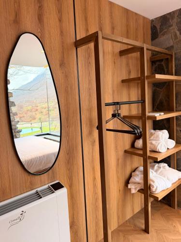 a circular mirror in a tiny house with a window at North Alpine Villas in Bogë
