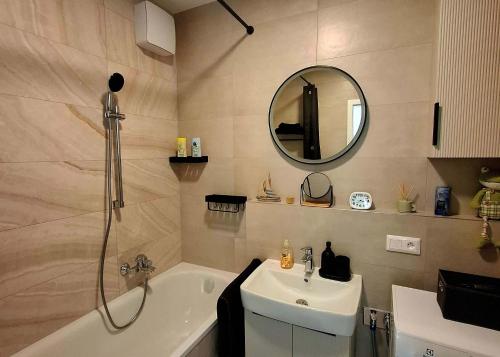 ein Badezimmer mit Waschbecken, Badewanne und Spiegel in der Unterkunft Sugar Apartment 41A in Trnava