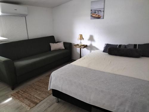 a living room with a bed and a couch at Kuća za odmor SIG in Erdevik