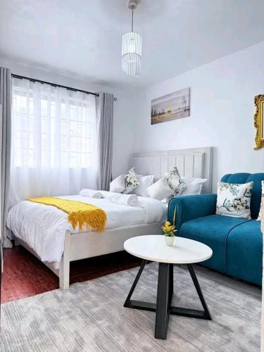 a bedroom with a bed and a couch and a table at Travel Nest in Nairobi