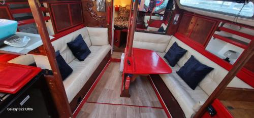 Un interior vacío de una autocaravana con un asiento rojo. en Grand voilier avec tout confort, en Cherbourg-en-Cotentin