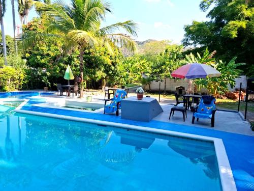 a pool with chairs and a table and an umbrella at family home in Honda
