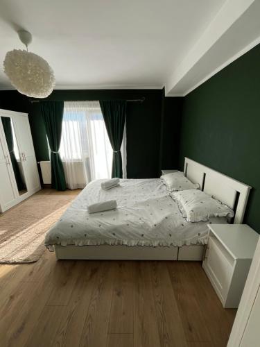 a bedroom with a bed and a green wall at Apartament The Office-Scorțarilor Cluj in Cluj-Napoca