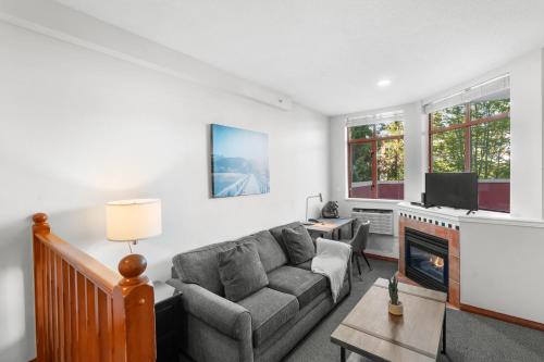 a living room with a couch and a fireplace at Alpenglow Lodge Large Studio with Dedicated Work Space by MVA in Whistler
