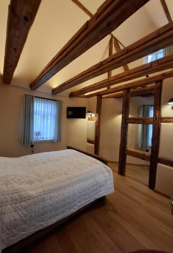 a bedroom with a large bed with wooden beams at Gästehaus Grüner Baum in Oestrich-Winkel