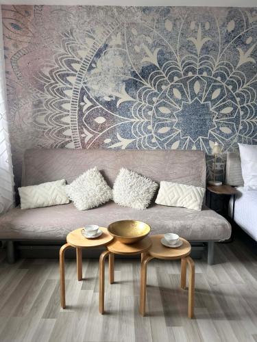 ein Wohnzimmer mit einem Sofa und 2 Tischen in der Unterkunft Kawałek Świata - pokoje nad morzem in Darłowo