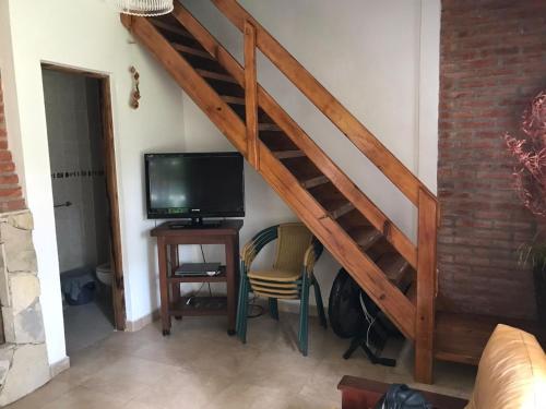 a living room with a staircase with a tv and a chair at okin 11 flores in Costa del Este