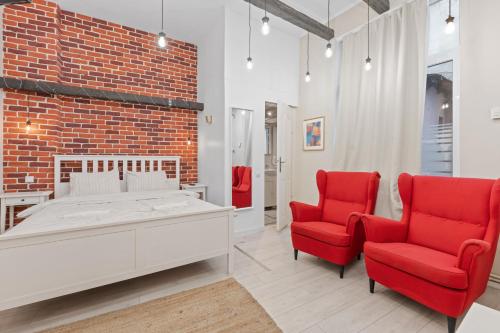 una camera da letto con un letto e due sedie rosse di The Brick Loft 1BR Calea Victoriei a Bucarest