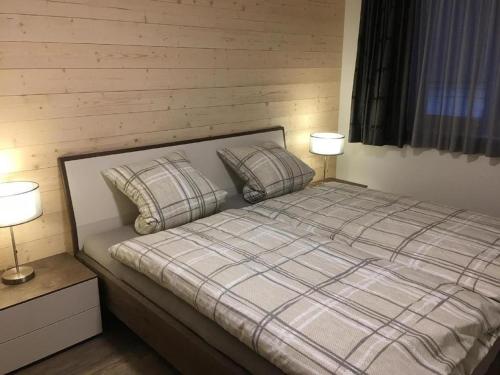 a bedroom with a bed with two pillows and two lamps at Katharina Von Allmen in Wengen