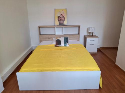 a bedroom with a large bed with a yellow blanket at Osvalley Résidence in Basse-Terre