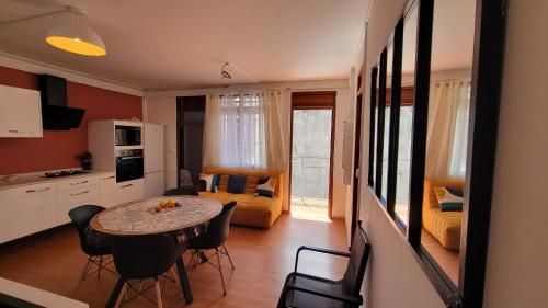 eine Küche und ein Wohnzimmer mit Tisch und Stühlen in der Unterkunft Osvalley Résidence in Basse-Terre