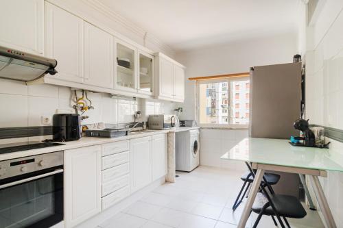 a kitchen with white cabinets and a green counter top at Apartamento para 6 hóspedes em Queluz próximo Lisboa,Sintra e Cascais in Queluz