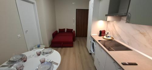 a small kitchen with a table and a red couch at Appartamento Padova Chiesanuova in Padova