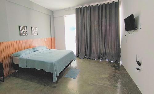 ein Schlafzimmer mit einem Bett und einem großen Fenster in der Unterkunft Asas da Maré Pousada in Bragança