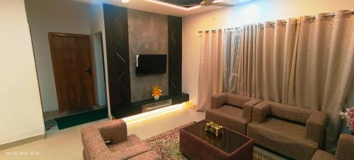 a living room with a couch and a tv at GK appartments in Bengaluru