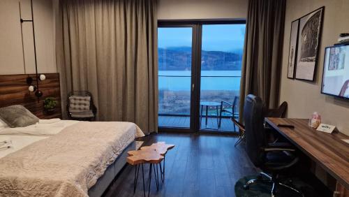 a hotel room with a bed and a desk and a window at Woda i góry - studio z widokiem na góry i zalew in Sosnówka