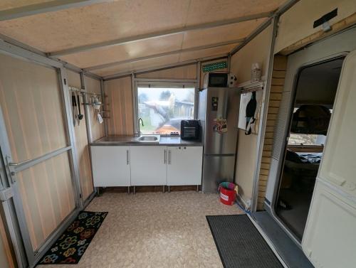 una vista interna della cucina di un camper con un lavandino di Wohnwagen mit feststehendem Vorzelt a Fehmarn