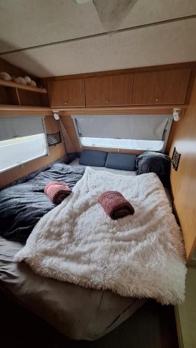 a bed in the middle of a room at Wohnwagen mit feststehendem Vorzelt in Fehmarn