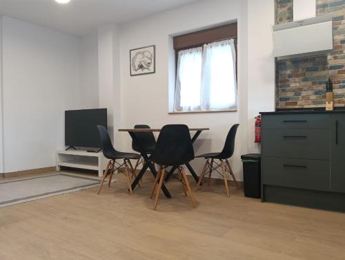 a kitchen with a table and chairs and a television at Apartamentos ROSAMUNDA SANTANDER in Santander
