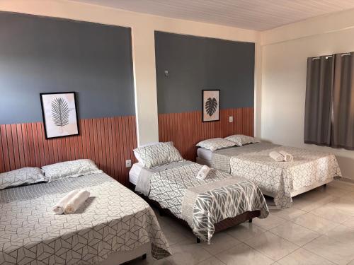 ein Zimmer mit zwei Betten und zwei Ottomanen in der Unterkunft Asas da Maré Pousada in Bragança