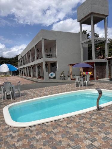 a swimming pool in front of a building at Asas da Maré Pousada in Bragança