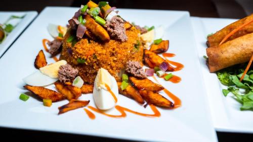 un piatto bianco di cibo con patatine fritte e carne di Las Vegas Beach Resort And Hotel a Fete