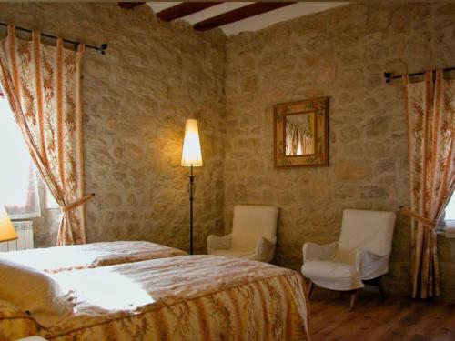 La Casa de las Monjas في Miranda de Arga: غرفة نوم بسرير وكرسيين ومصباح