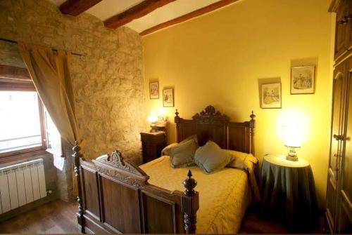 La Casa de las Monjas في Miranda de Arga: غرفة نوم بسرير وجدار حجري