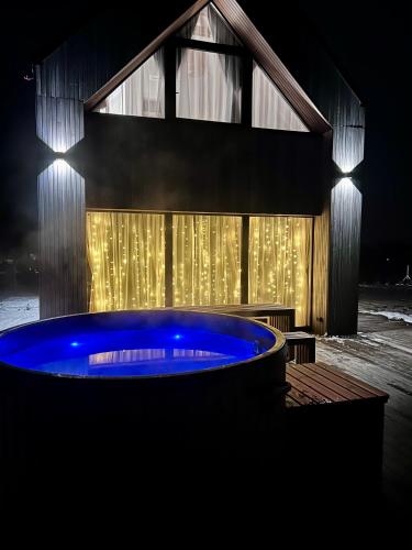 a large blue tub in front of a building at night at Stodoła Na Widoku z Balią in Radków