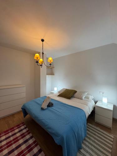 a bedroom with a large bed with a blue blanket at Ático luminoso en Felechosa in Felechosa