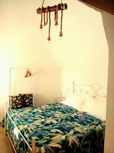 a bedroom with a bed with a green comforter at Trulli Donna Grazia in Martina Franca