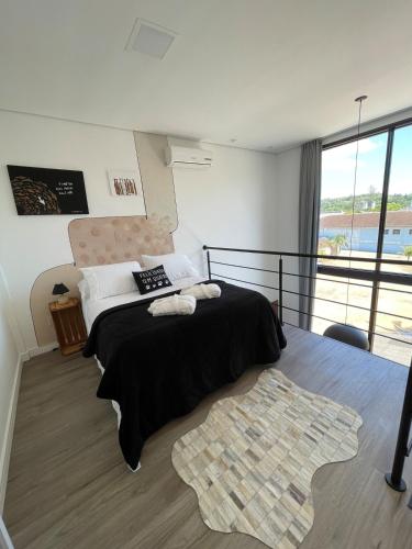 a bedroom with a large bed with a black blanket at Apartamento Texas in Pomerode