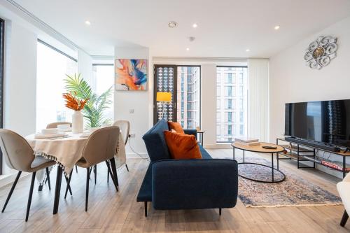 a living room with a blue chair and a table at Pet friendly 2BR City Centre Apartment - Near Piccadilly in Manchester