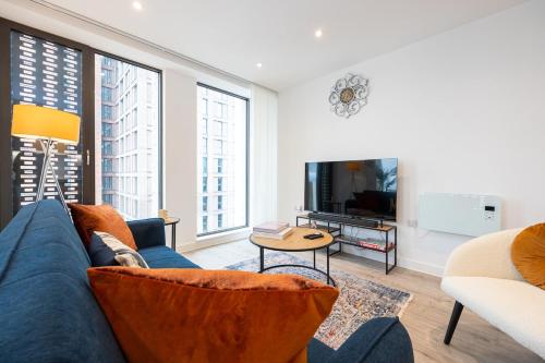 a living room with a blue couch and a tv at Pet friendly 2BR City Centre Apartment - Near Piccadilly in Manchester