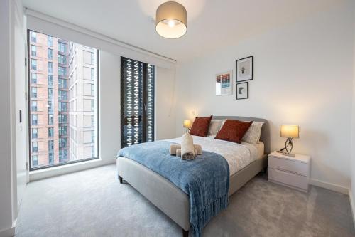 ein Schlafzimmer mit großem Bett und großen Fenstern in der Unterkunft Pet friendly 2BR near Piccadilly in Manchester