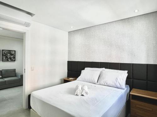 ein Schlafzimmer mit einem Bett mit zwei Hausschuhen darauf in der Unterkunft Casa Pantuso no coração de BH in Belo Horizonte