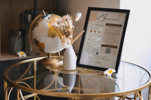 a globe on a glass table next to a laptop at PrestigeLodgesFontainebleau, Maison polynésienne & jacuzzi privé in Pamfou
