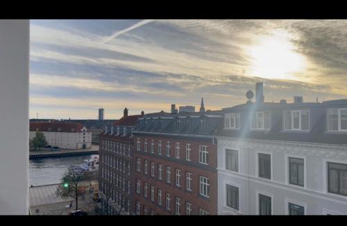 a view of a building with the sun setting behind it at Hotel Maritime in Copenhagen