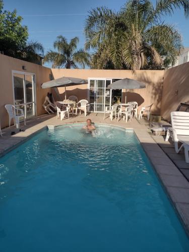 a man in a swimming pool with chairs and umbrellas at Sol de Belen in San José