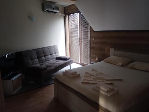 a bedroom with a large bed and a couch at Paradise in Burgas City