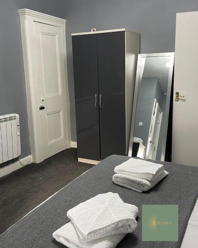 a bathroom with two towels on a bed and a mirror at Orlando Llandundo Apartment in Llandudno