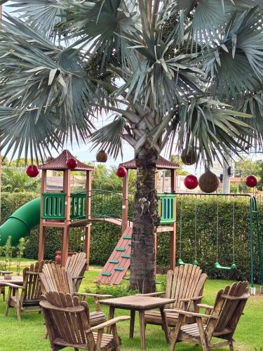 a playground with a table and chairs and a palm tree at Hotel Roda D'Agua in Andradina