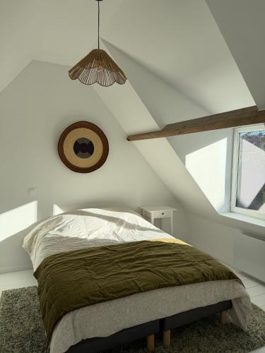 a bedroom with a bed and a clock on the wall at Le426 Charmant T2 bis avec petite cour in Mouvaux
