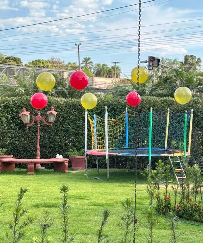 a swing in a yard with a playground at Hotel Roda D'Agua in Andradina
