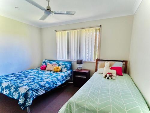 Un dormitorio con dos camas y una ventana. en JP Homestay Private Rooms in Homely Shared Home in North Booval, Ipswich City, en Bundamba