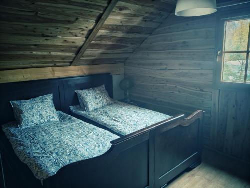een bed in een kamer met een houten wand bij Nowy Gaj in Wilczyn