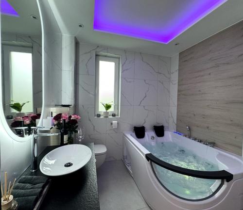 乌斯特龙Apartament z wanną z hydromasażem的带浴缸、马桶和水槽的浴室